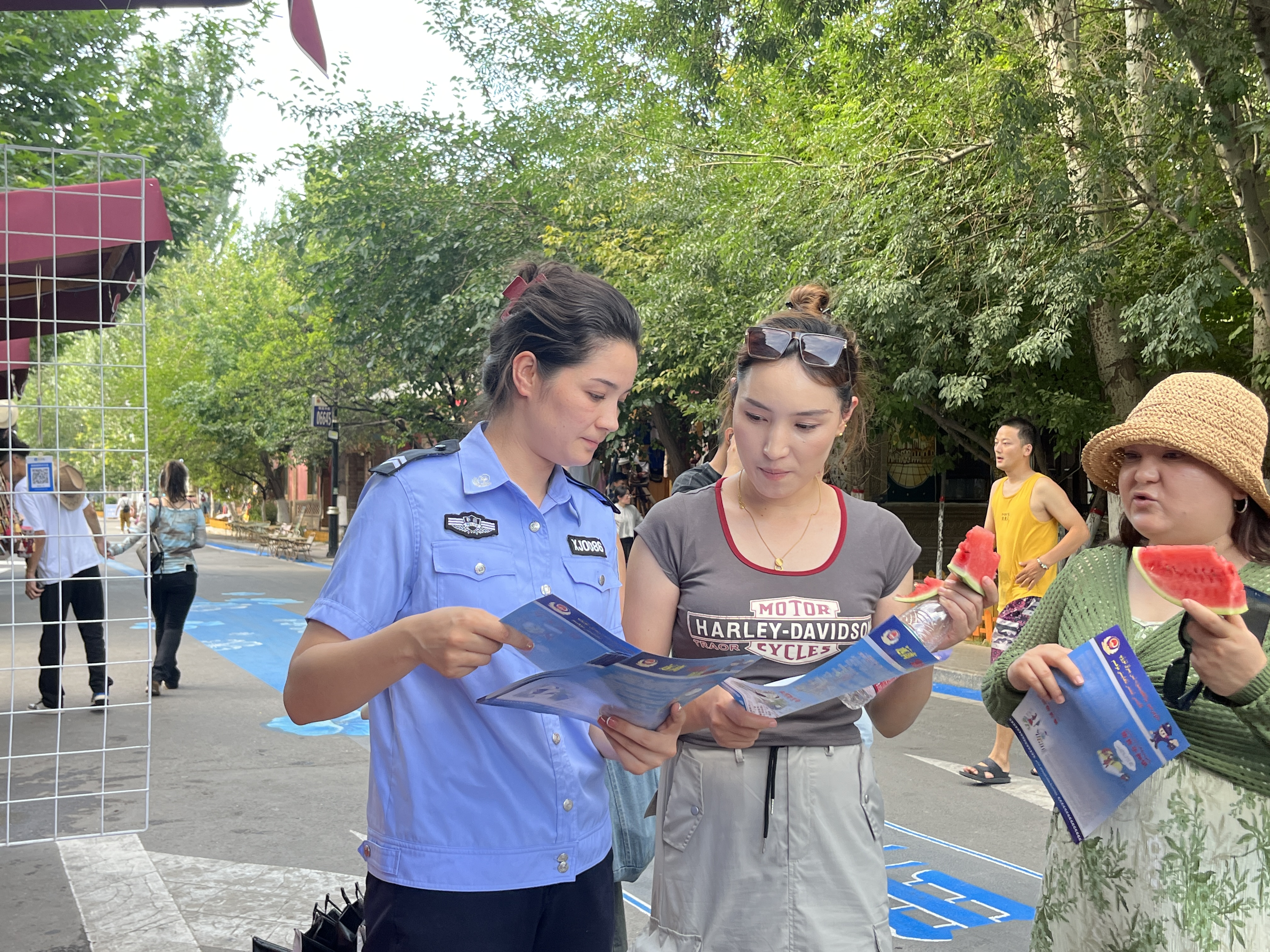 解放路派出所民警向六星街游客進(jìn)行普法宣傳工作并送去解暑的西瓜、綠豆湯。1.jpg